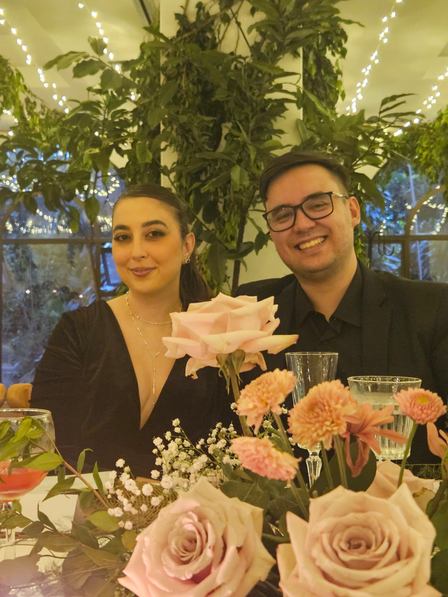 Bárbara e William arrumados em uma festa cheia de flores