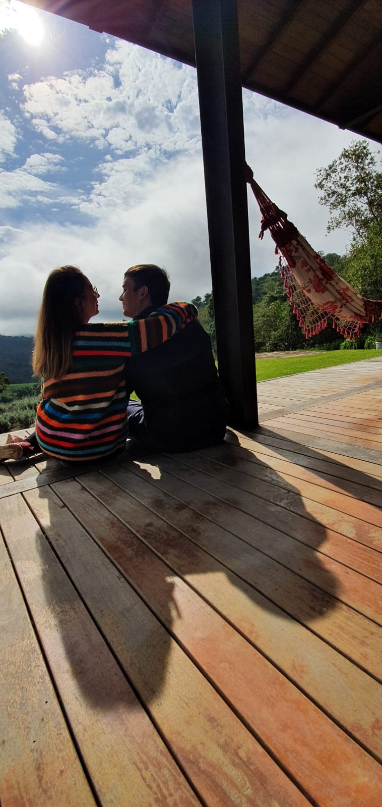 Bárbara e William sentados na varanda olhando a paisagem